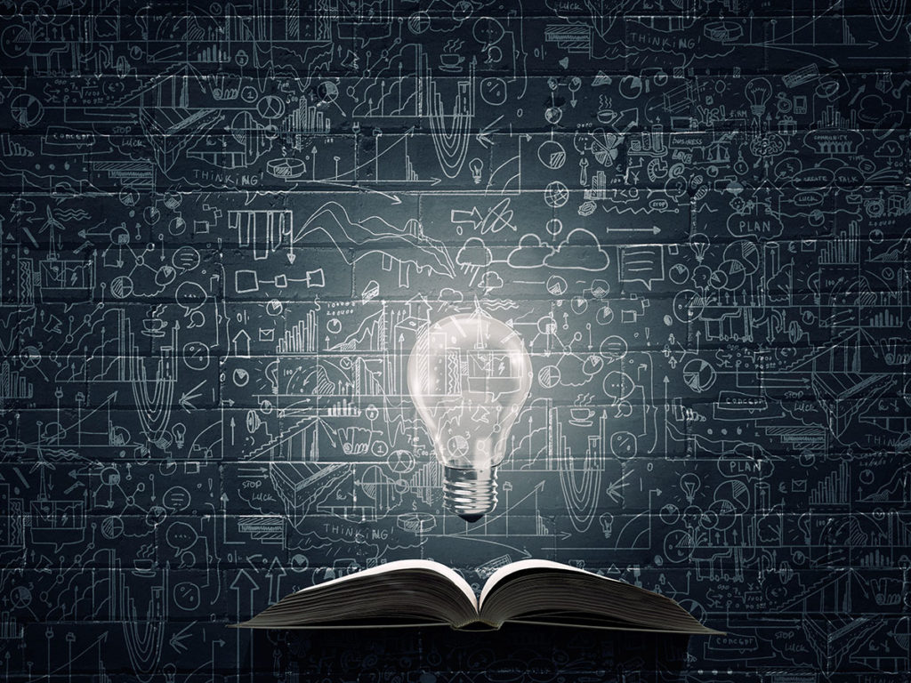 "Illustration of a light bulb glowing above an open book, with chalkboard sketches in the background."