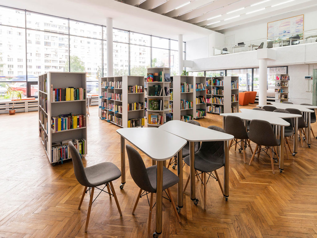 "Interior view of a bright library with bookshelves and study tables."