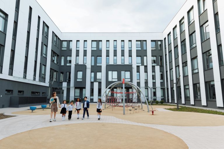 A group of children joyfully walking around a playground, exploring various play structures and enjoying their time together